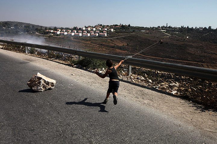 24 hours: A Palestinian boy uses a slingshot to hurl a stone