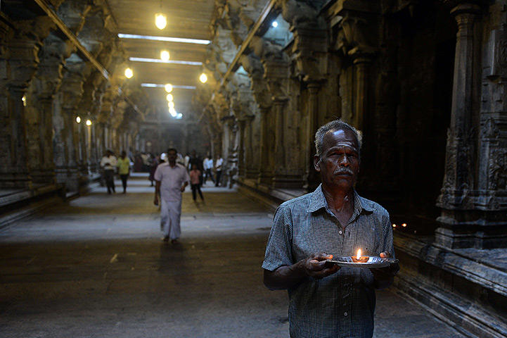 24 hours: Colombo, Sri Lanka: A man offers prayers at a Hindu temple 