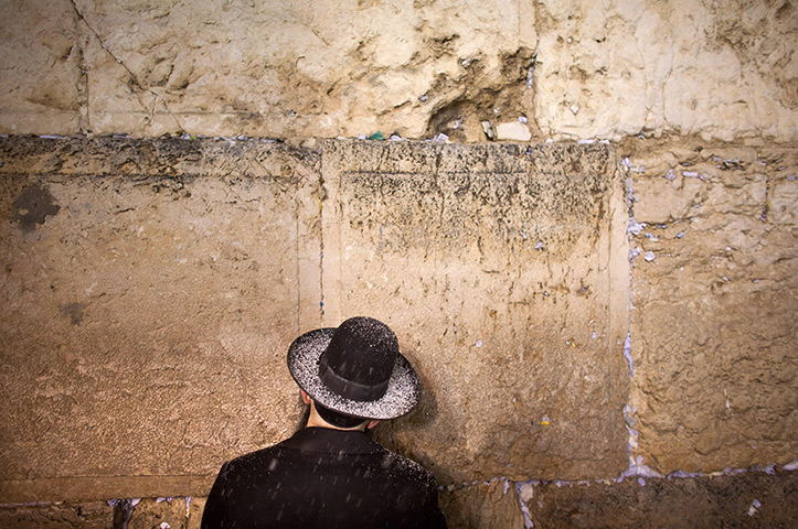 Snow in Jerusalem: An ultra-Orthodox Jewish man prays as snow falls