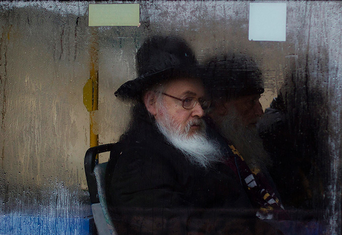 Snow in Jerusalem: An ultra-Orthodox Jewish man looks out of a fogged up bus window