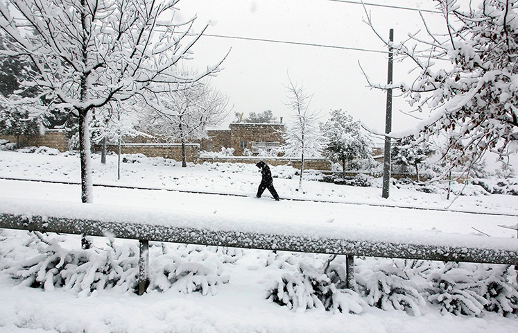 Snow in Jerusalem: A pedestrian walks on a snow-covered street in east Jerusalem