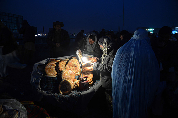24 hours in pictures: Afghan man buying bread from a vendor