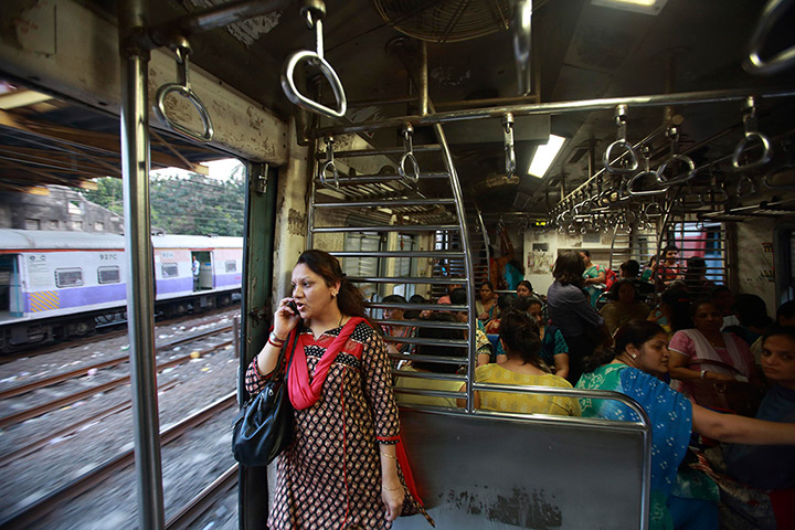 Trains for women: A woman speaks on the phone as she stands near the open doorway