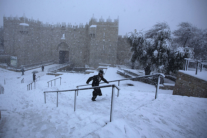 Snow in Jerusalem: An ultra-Orthodox Jewish man runs as snow falls