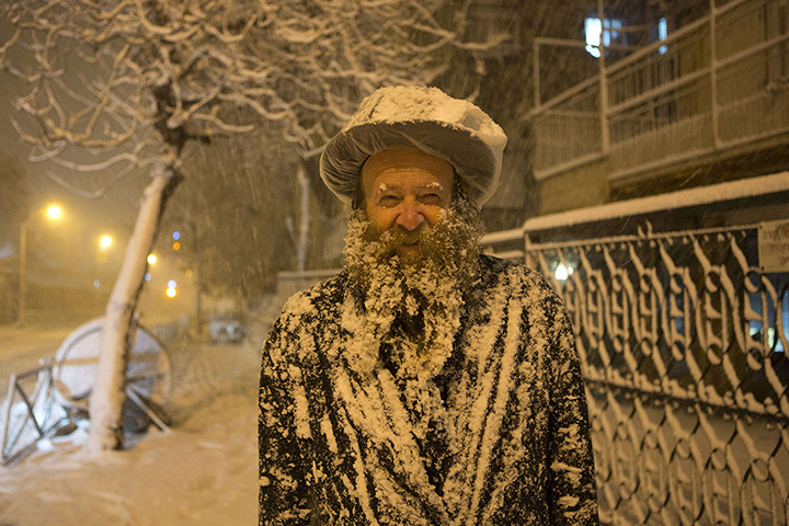 Snow in Jerusalem: An ultra-Orthodox Jewish man covered with snow 