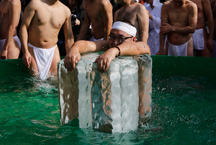 24 hours in pictures: A man holds onto ice as he bathes in ice-cold water in Tokyo