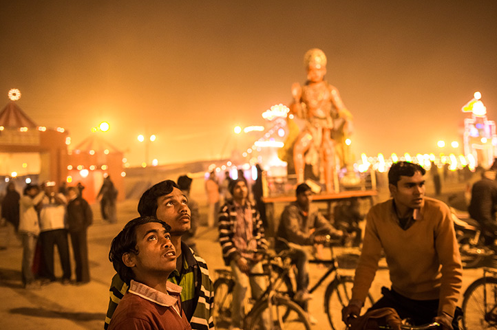 24 hours in pictures: Hindu devotees look up at the gate at Shri Panchayati Akhara Bara Udasin