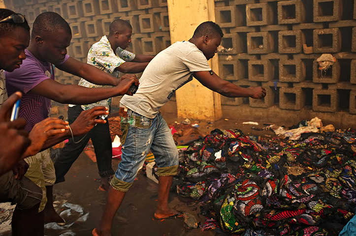 24 hours in pictures: People take pictures of damaged cloth ouside of Lome's Grand Marche 