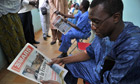 Mali man reads newspaper praising France