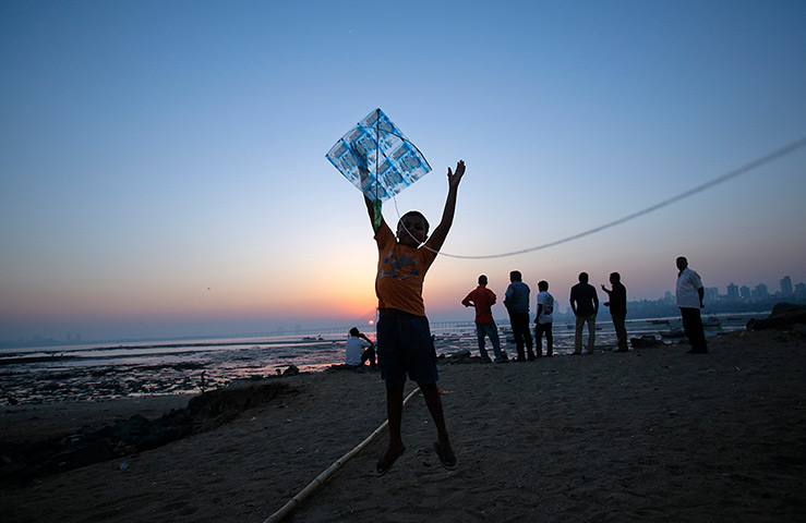 24 hours: Mumbai, India: A boy releases a kite during the Makar Sankranti festival