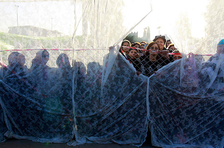 24 hours: Netivot, Israel: Women stand behind a curtain during an annual pilgrimage