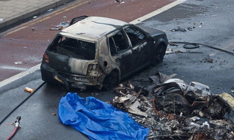 Debris and a fire damaged car are pictured at the scene of a helicopter crash in central London.