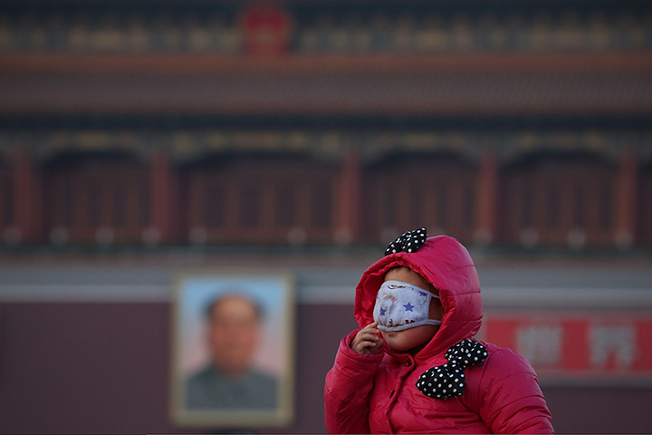 24 hours in pictures: A little tourist wearing the mask at the Tiananmen Square during pollution