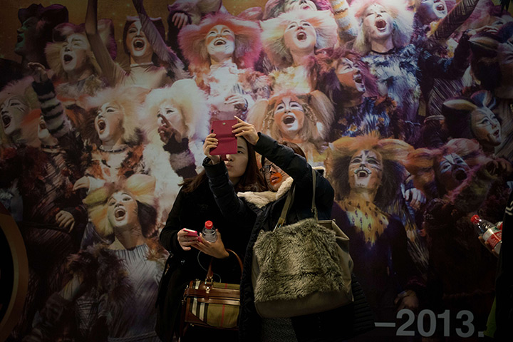 24 hours in pictures: Audience members posing before a poster of 'Cats'