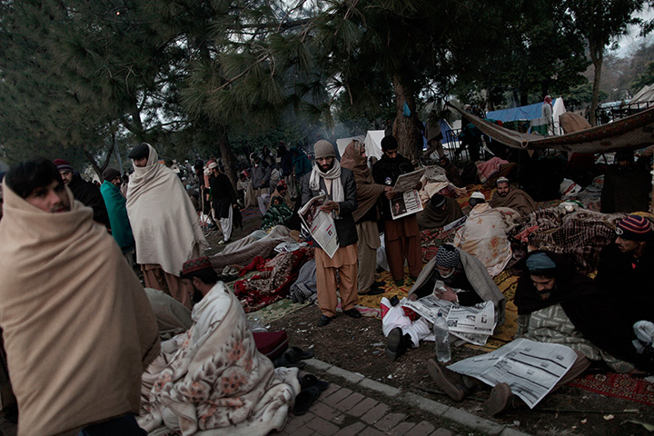 24 hours in pictures: Supporters of Pakistani Sunni Muslim cleric read local newspapers 