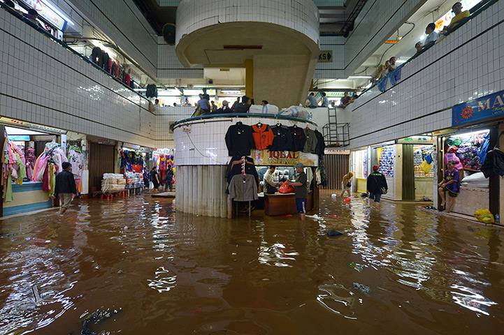 24 hours in pictures: Vendors operate their businesses as usual despite floodwaters