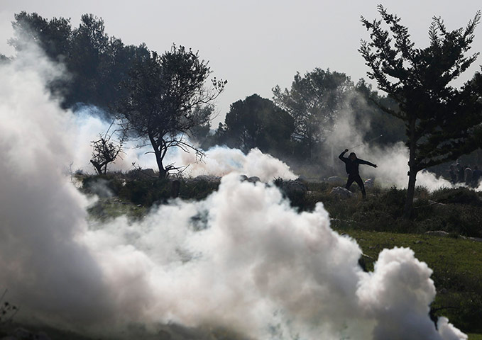 20 Photos: A Palestinian protester hurls a stone at Israeli officers near Ramallah