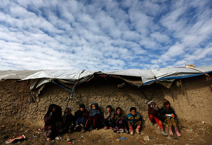 24 Hours: Internally displaced Afghan children sit near their refugee camp in Kabul