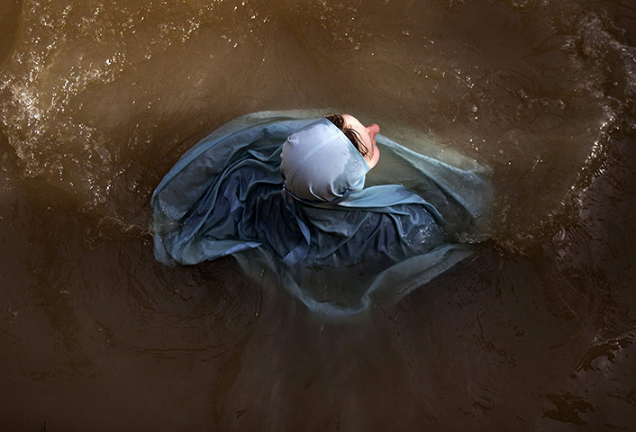 24 Hours: An Orthodox Christian nun plunges into the waters of the Jordan river in the West Bank during a ceremony marking the Feast of the Epiphany