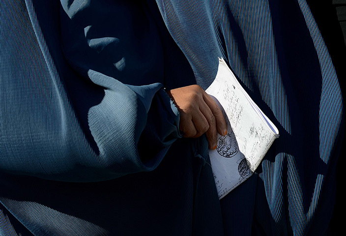 24 hours in pictures: An Afghan woman holds a ration form