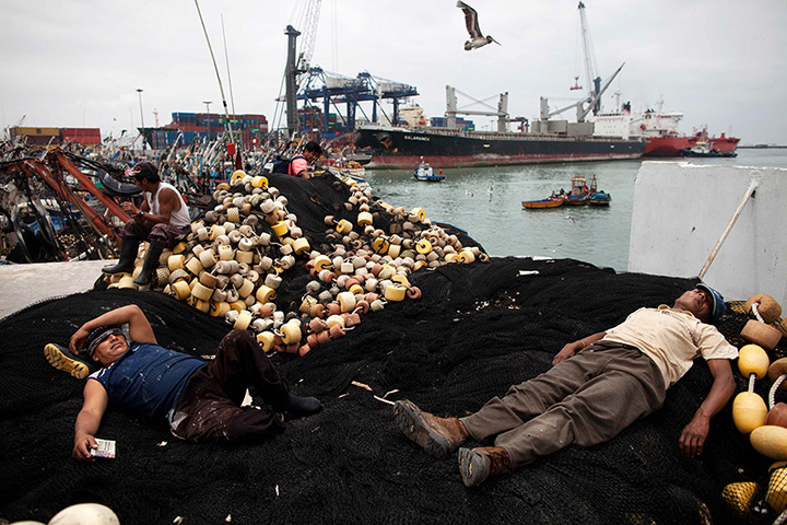 FTA: Rodrigo Abd: Fishermen rest on their docked fishing vessel at the port in El Callao
