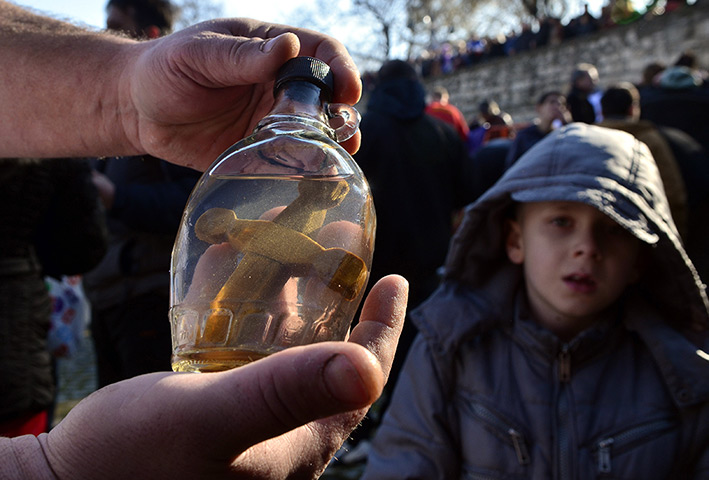 24 hours: Skopje, Macedonia: A man closes a bottle with a wooden cross