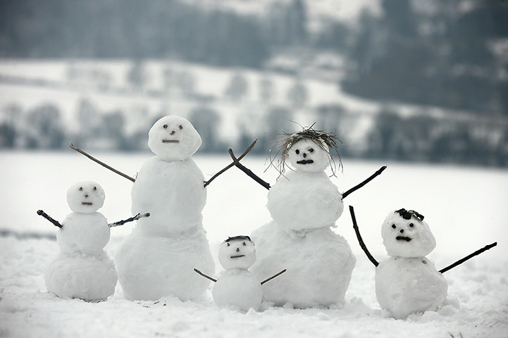 Snowy weather: Dorking:  A family of snowmen sit on Box Hill 