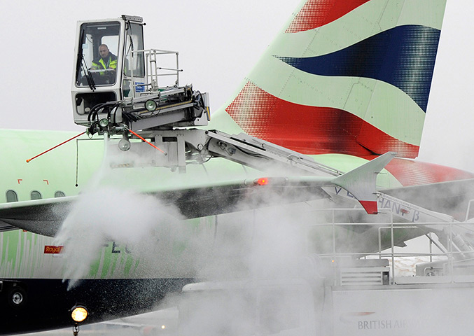 Snowy weather: Heathrow Airport: An airport employee de-ices a British Airways plane 