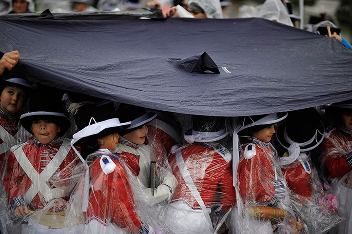 24 hours: San Sebastian, Spain: Tamborilleros wear protection against rain