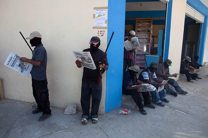 24 hours: Ayutla, Mexico: Masked and armed men read newspapers 