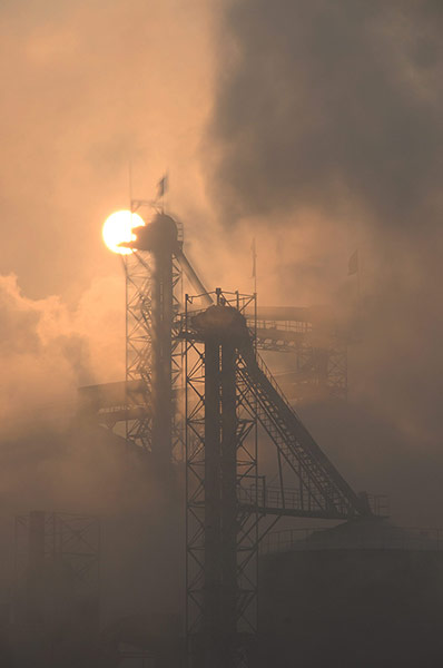 smog crisis in China: Chimneys of a cement plant emit smoke into the air