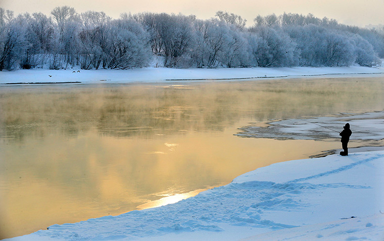 24 hours: Moscow, Russia: A man fishes from the banks of the Moscow river