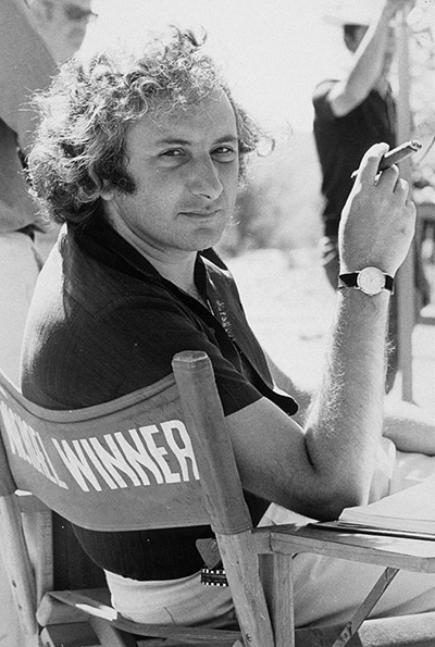 michael winner: Michael Winner smokes a trademark cigar in his director's chai