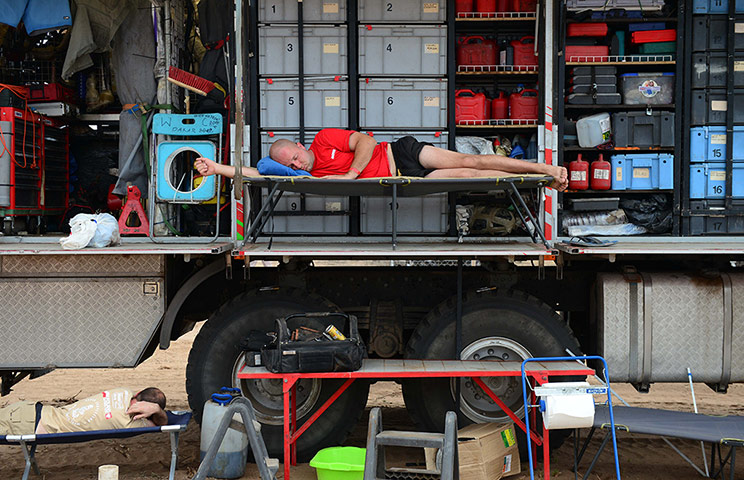 Dakar Rally: A mechanic rests on a truck