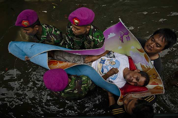 FTA: Ulet Ifansasti: Local resident Syamsuri is evacuated by soldiers from the Indonesian Army