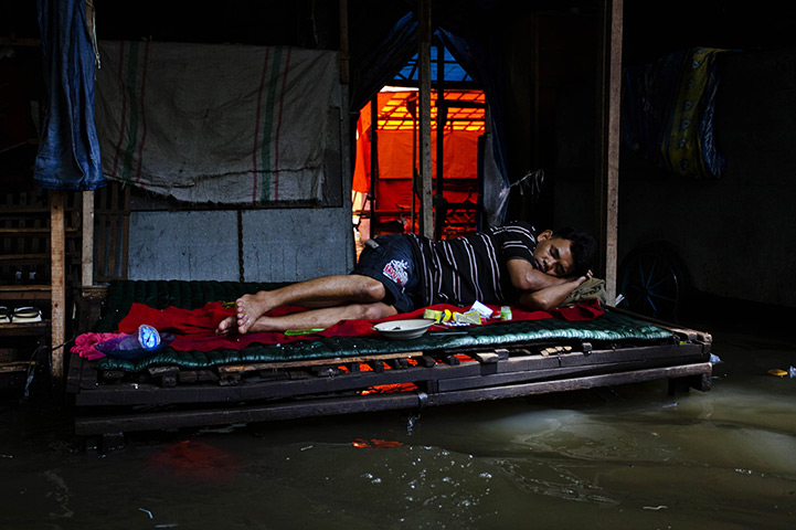 FTA: Ulet Ifansasti: A man sleeps as flood waters lap beneath his make-shift bed