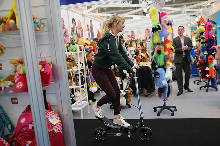 Toy Fair: A woman rides a scooter through trade stands