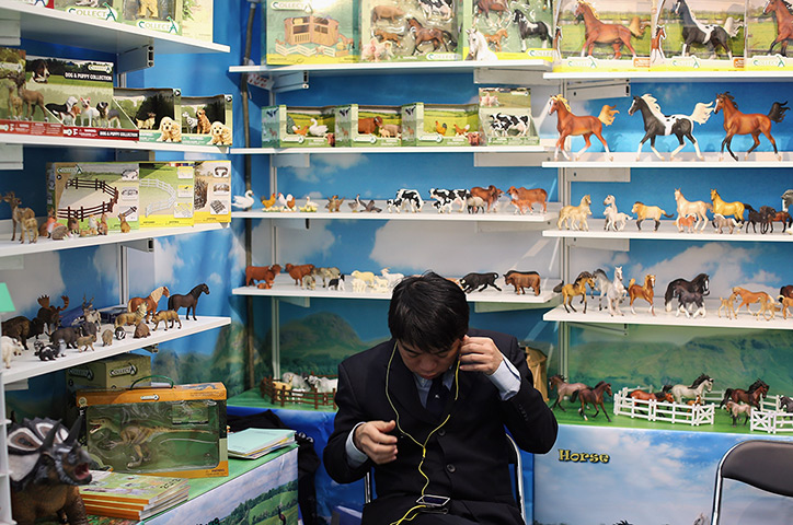 Toy Fair: A man sits on a model horse stand 