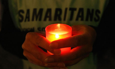 A Samaritans volunteer holds two candles during a vigil to remember those who have died by suicide in Dublin. Photograph: Niall Carson/PA Vigil for World Suicide Prevention Day