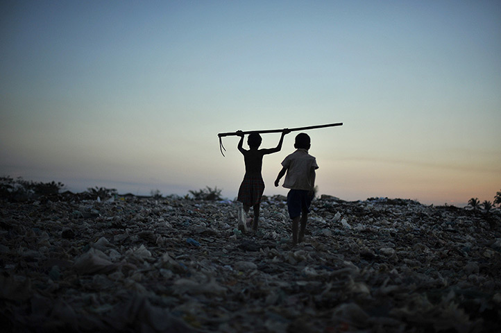 24 hours: Rangoon, Burma: A boy holds a tool used to collect material