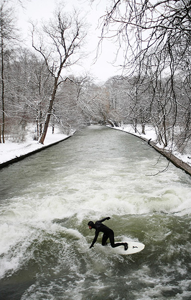24 hours: Munich, Germany: A surfer rides the man-made wave at the Eisbach