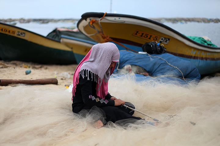 24 hours: Gaza City, Gaza Strip: A girl mends fishing nets