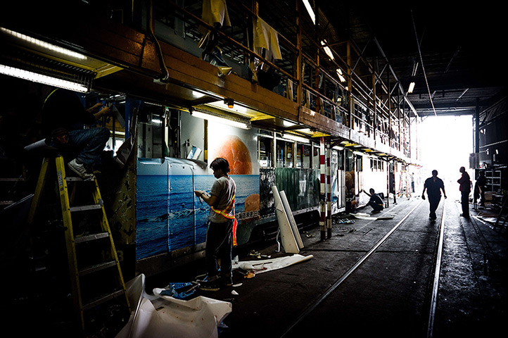 24 hours: Hong Kong, China: A worker applies an adhesive advert