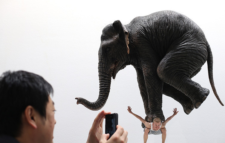 24 hours: Singapore: A man photographs a statue entitled Pentateuque