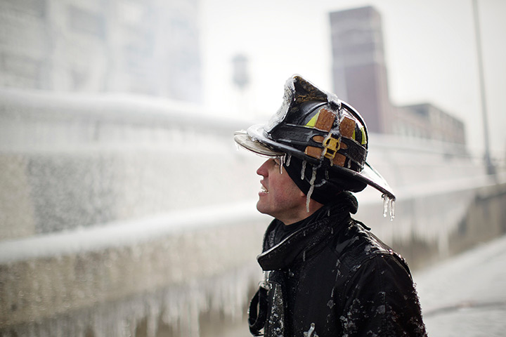 24 hours in pictures: Firefighter Michael De Jesus is covered in ice