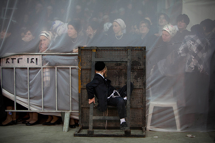 24 hours in pictures: Jewish women are seen behind a curtain during a traditional Jewish wedding