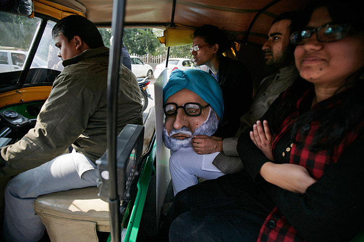 24 hours in pictures: auto rickshaw with the mask of Indian Prime Minister Manmohan Singh