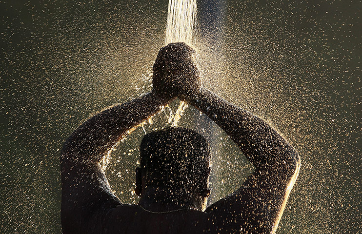 24hours: Kuala Lumpur, Malaysia: A Hindu devotee takes a ceremonial bath