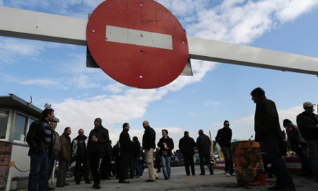 Striking workers gather at the entrance of a bus depot during a 24-hour walkout in Athens. Photograph: Reuters/John Kolesidis