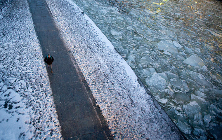 24 hours: A man walks along the bank of the river Spree on a cold day 